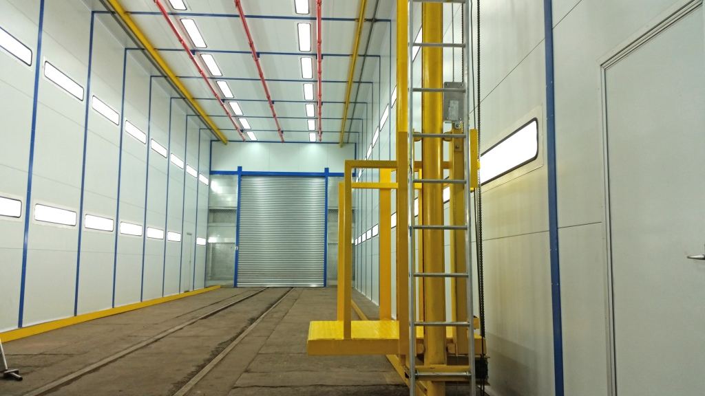 Locomotive paint booth with a powered man-rider platform